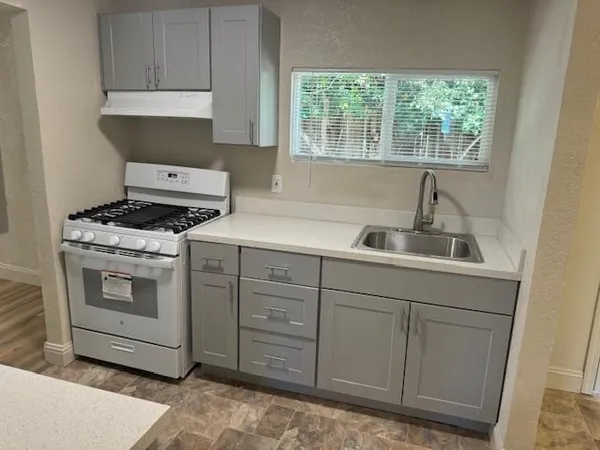 a kitchen with cabinets appliances and a window