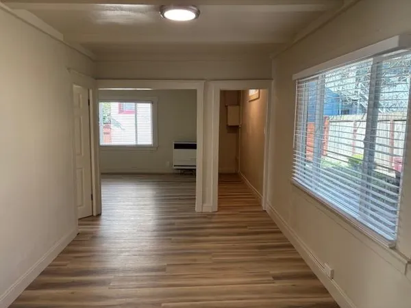 a view of a hallway with wooden floor and windows