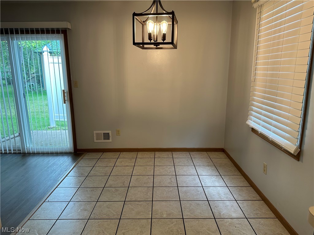 6431 Shaffer Road Northwest Warren, OH 44481 - Photo 7 of 20 Tiled empty room featuring an inviting chandelier