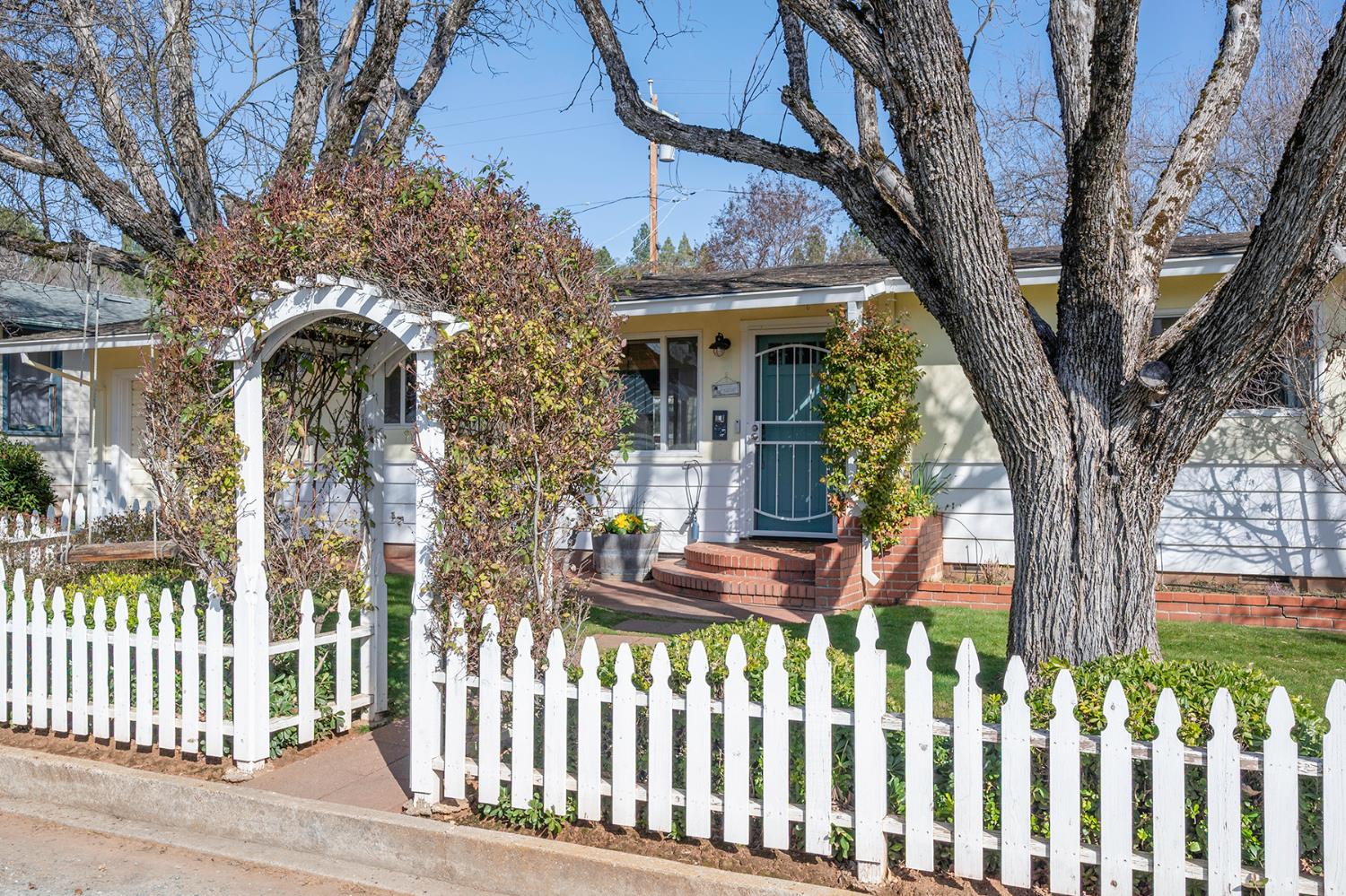 a front view of a house with a tree