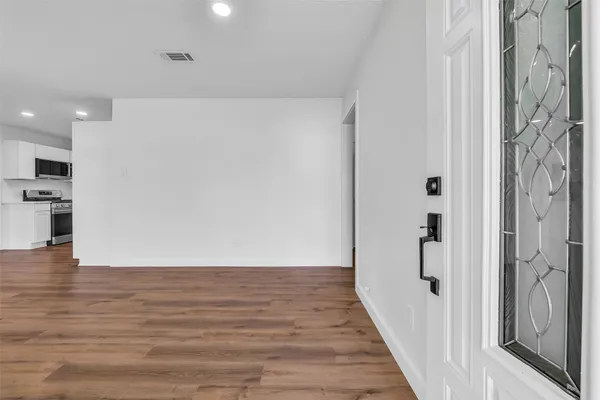 a view of a hallway with wooden floor