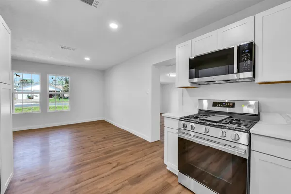 a kitchen with stainless steel appliances a stove a microwave and cabinets