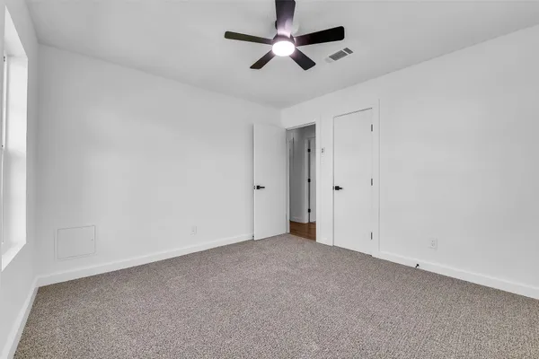 an empty room with chandelier fan