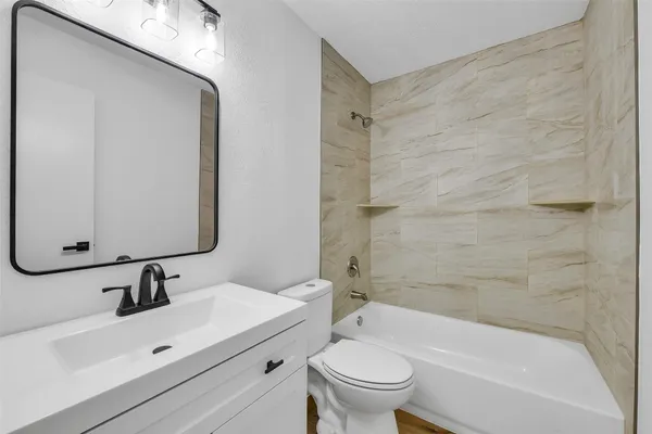 a bathroom with a sink mirror toilet and bathtub