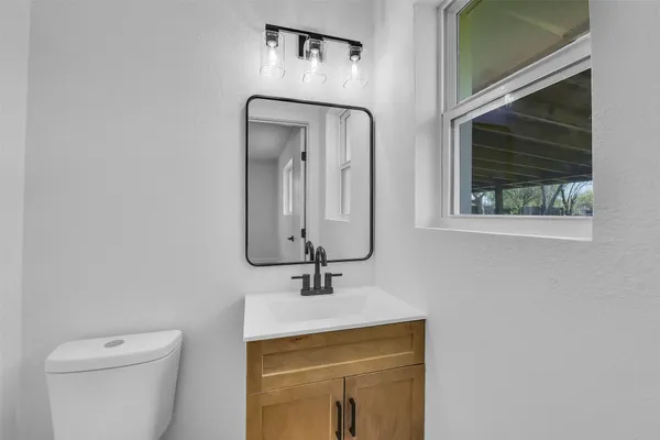 a bathroom with a toilet sink and mirror