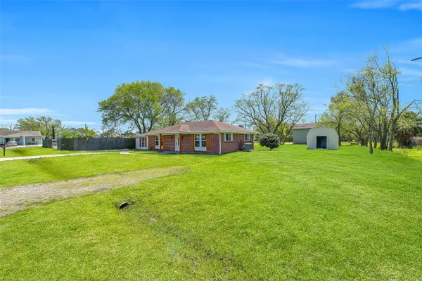 a front view of a house with garden and trees