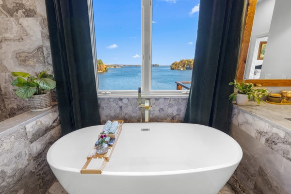 516 Hillandale Road Seneca, SC 29672 - Photo 19 of 50 This serene bathroom offers a soaking tub with an expansive water view, creating a tranquil retreat.