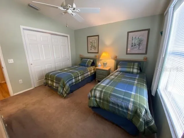 a spacious bedroom with two beds and a chandelier