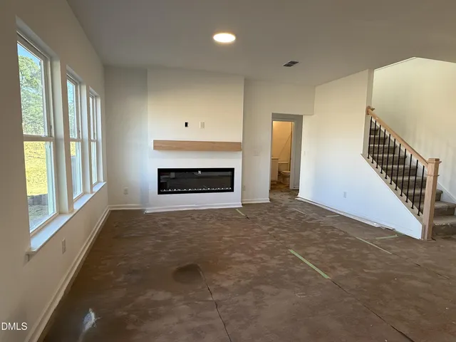 a view of an empty room with a fireplace and a window
