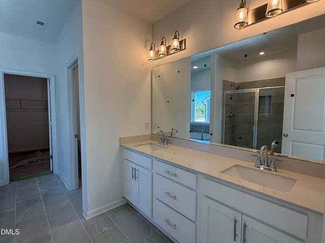 a bathroom with a double vanity sink and a mirror