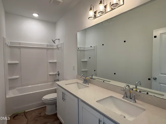 a bathroom with a granite countertop sink a toilet and shower