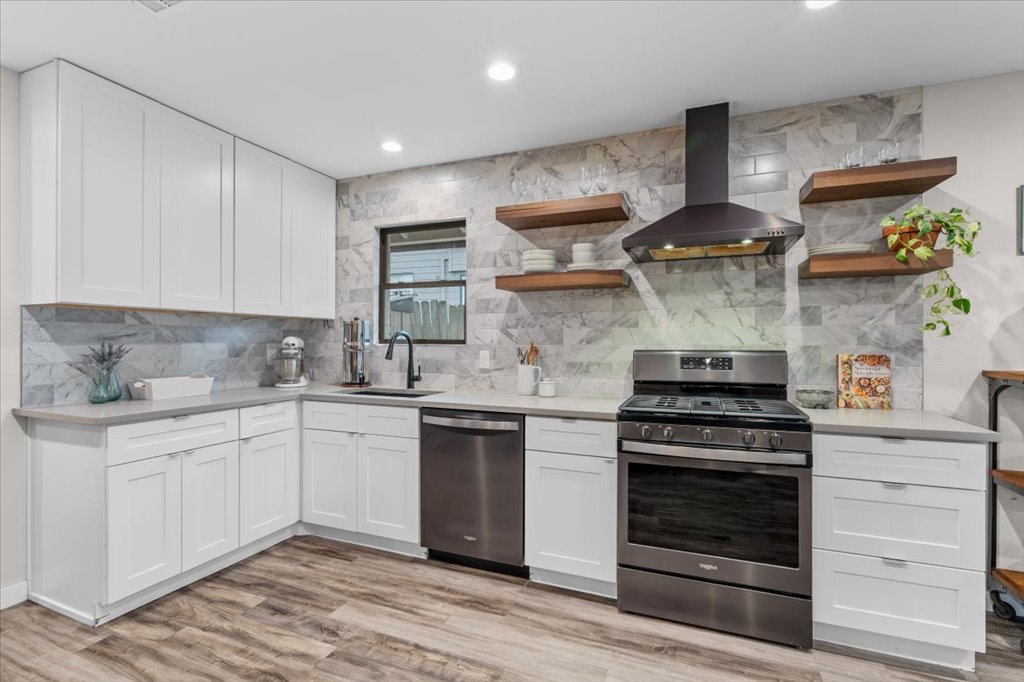 3010 Burleson Road, Unit A Austin, TX 78741 - Photo 11 of 28 Kitchen featuring stainless steel appliances, open shelves, white cabinets, light stone countertops, and decorative backsplash