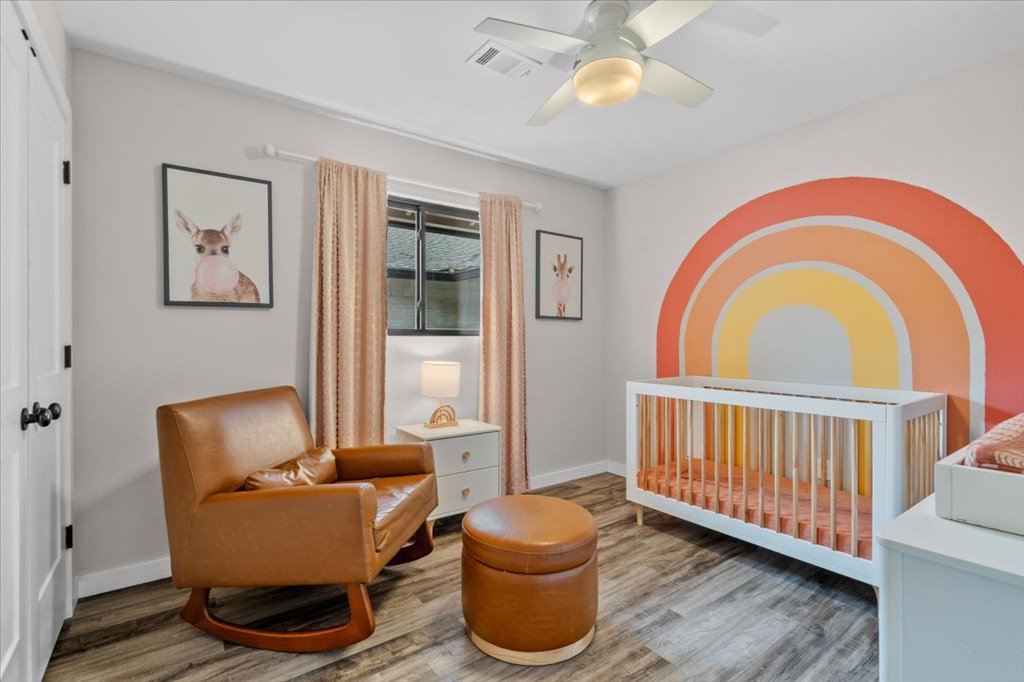 3010 Burleson Road, Unit A Austin, TX 78741 - Photo 19 of 28 Bedroom with a nursery area, light wood-style flooring, ceiling fan, and a closet