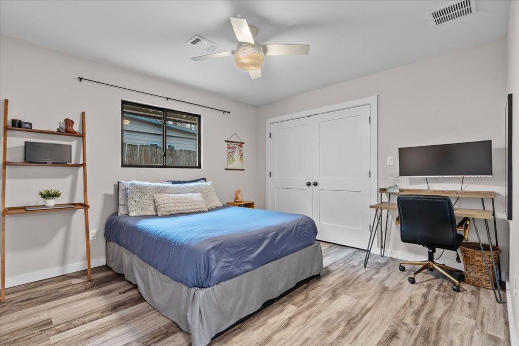 3010 Burleson Road, Unit A Austin, TX 78741 - Photo 21 of 28 Bedroom with light wood-type flooring, an office area, a closet, and ceiling fan
