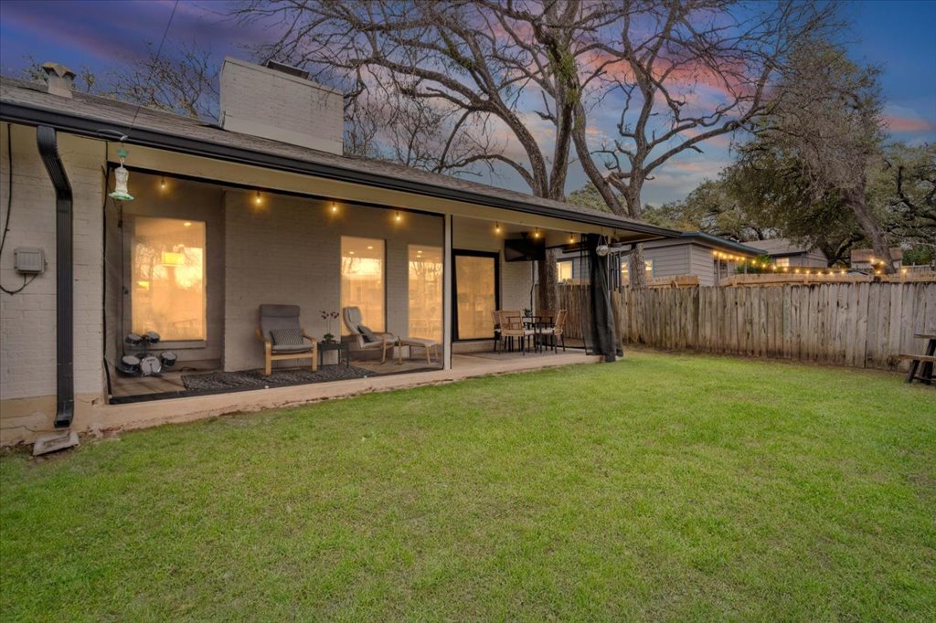 3010 Burleson Road, Unit A Austin, TX 78741 - Photo 3 of 28 Back of house at dusk featuring a chimney, brick siding, and a patio area