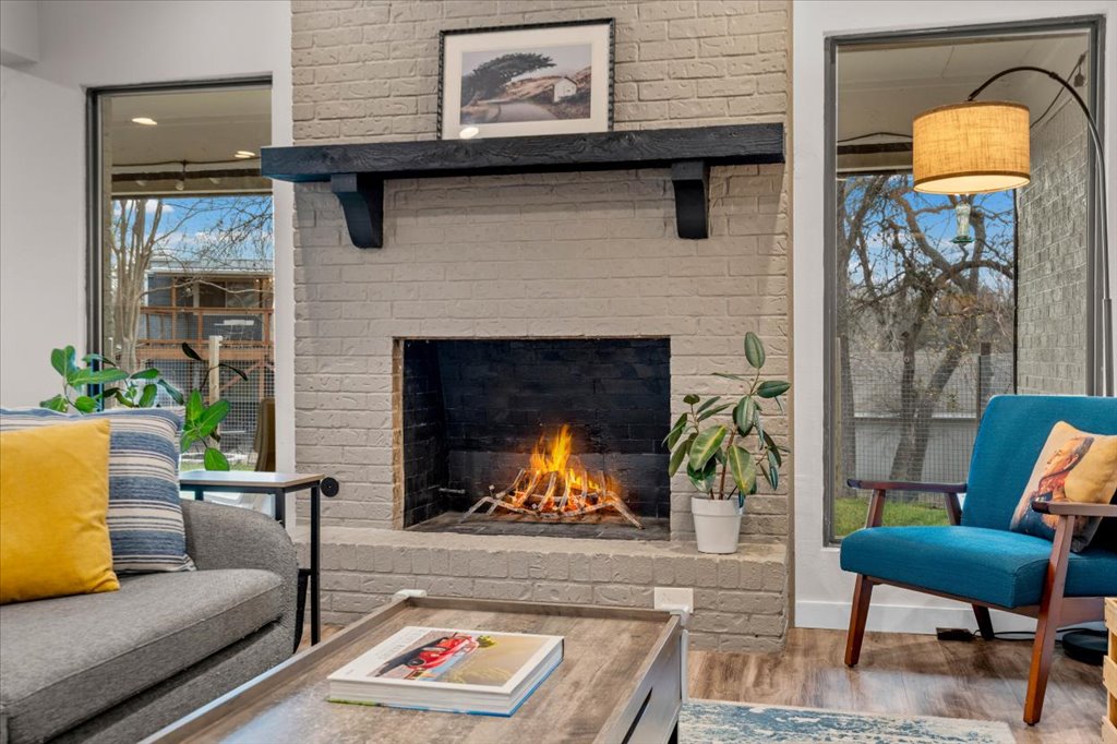 3010 Burleson Road, Unit A Austin, TX 78741 - Photo 7 of 28 Living area with an outdoor brick fireplace and wood finished floors