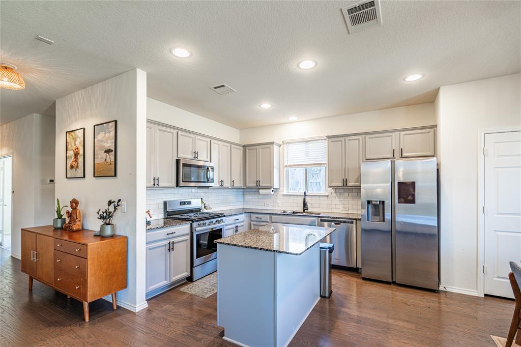 547 Saturnia Drive Georgetown, TX 78628 - Photo 14 of 39 a kitchen with white cabinets and stainless steel appliances