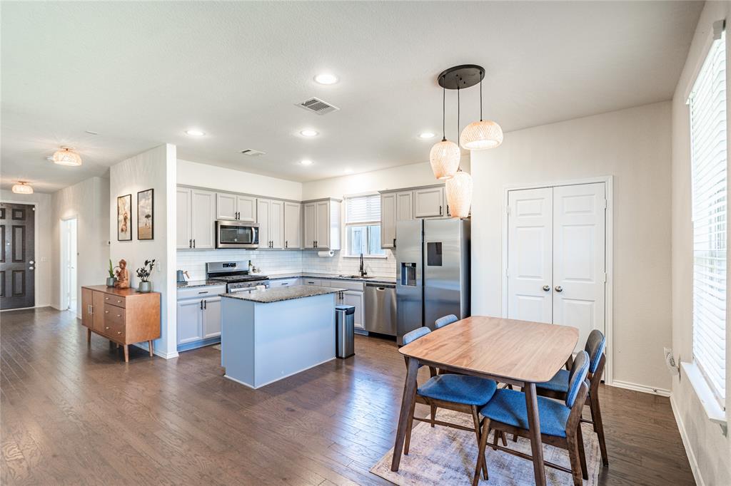 547 Saturnia Drive Georgetown, TX 78628 - Photo 20 of 39 a open kitchen with stainless steel appliances granite countertop a stove a refrigerator a kitchen island a dining table and chairs with wooden floor