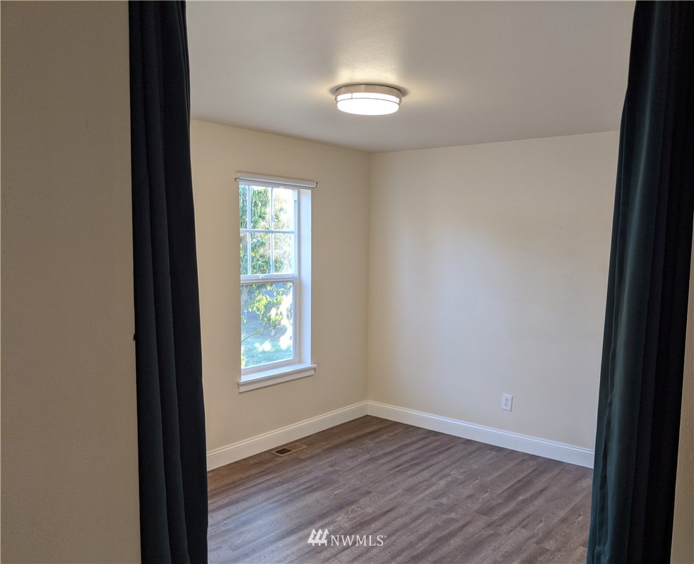 3224 Locust Avenue Bellingham, WA 98225 - Photo 6 of 28 an empty room with wooden floor and windows