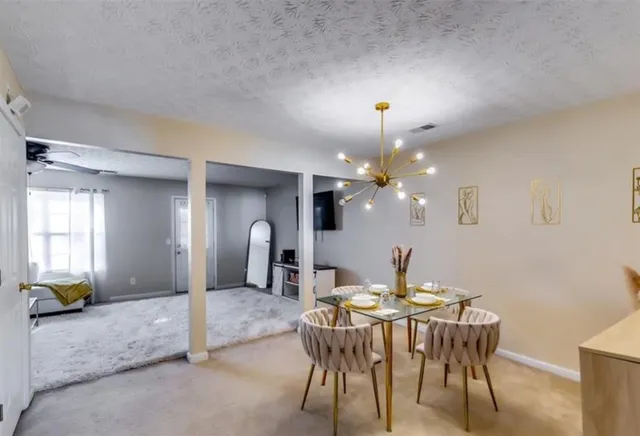 a dining room with furniture and a chandelier