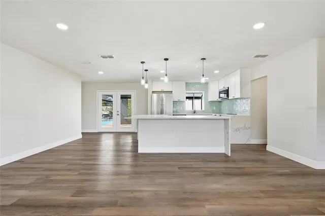 a kitchen with a refrigerator sink and cabinets