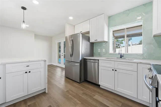 a living room with furniture kitchen view and a wooden floor