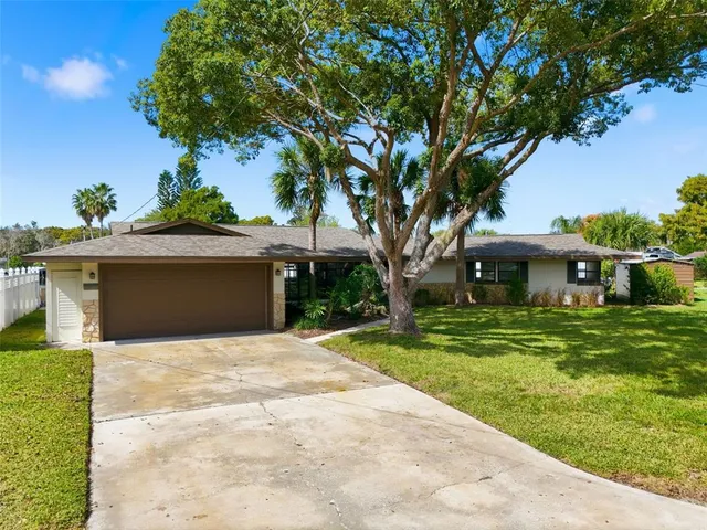 a front view of a house with a yard and trees