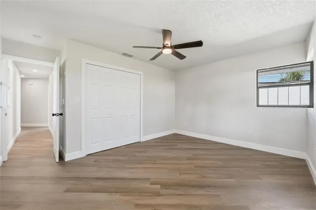 a view of an empty room with wooden floor