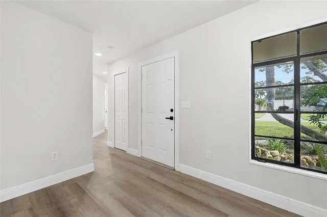 a kitchen with stainless steel appliances granite countertop white cabinets a sink a stove a microwave and wooden floors