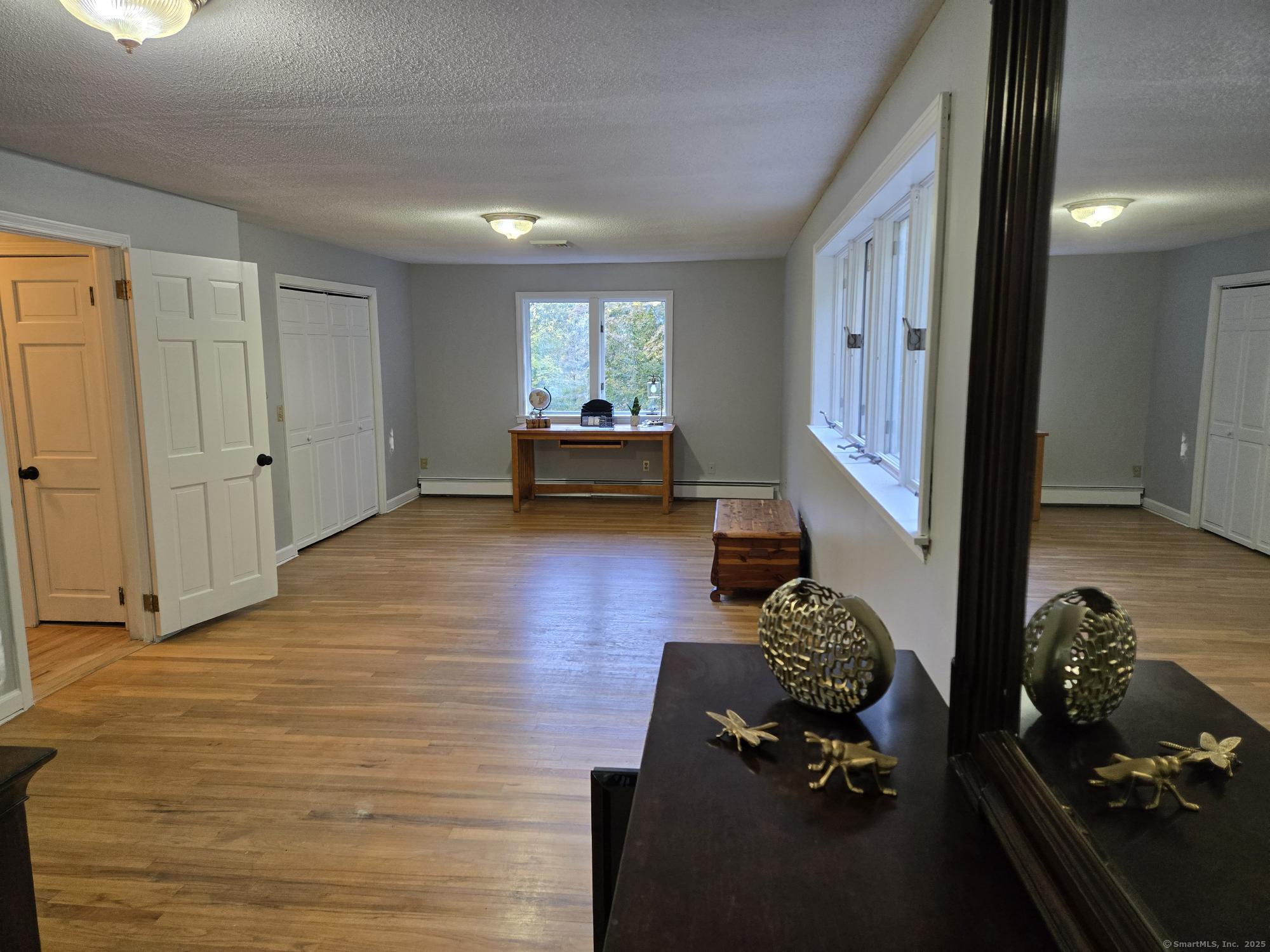 297 Wickham Road Glastonbury, CT 06033 - Photo 29 of 39 a living room with furniture floor to ceiling window and a wooden floor