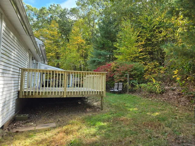 a view of a house with a yard deck and a slide