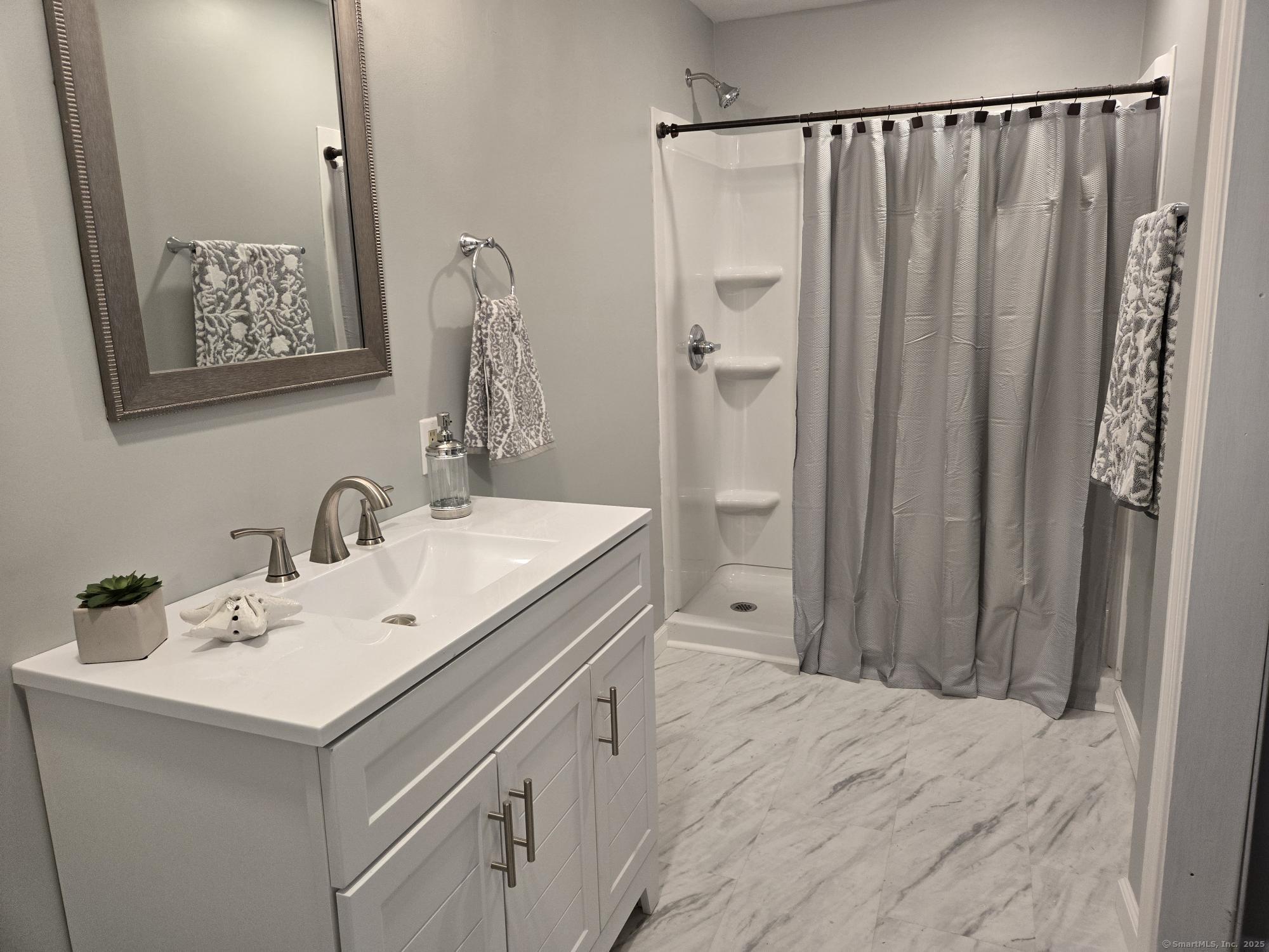 297 Wickham Road Glastonbury, CT 06033 - Photo 32 of 39 a bathroom with a double vanity sink and a mirror