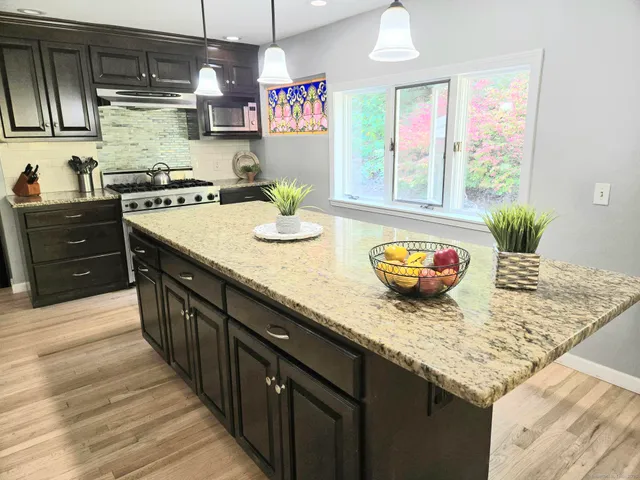 a kitchen with stainless steel appliances granite countertop a stove and a sink