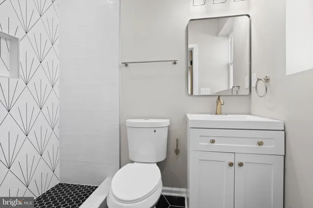 a bathroom with a toilet a sink a vanity and mirror