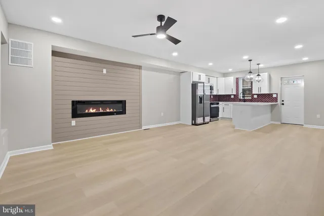 a open kitchen view with a stove refrigerator and cabinets