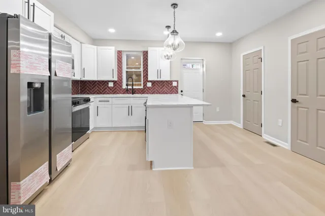 a large kitchen with cabinets and stainless steel appliances
