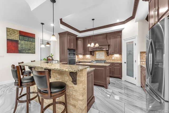 a kitchen with a dining table chairs sink and cabinets