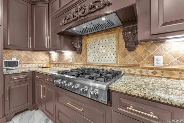a kitchen with granite countertop a sink a stove and cabinets