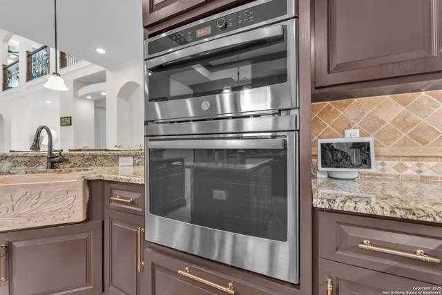 a kitchen with granite countertop stainless steel appliances and wooden cabinets