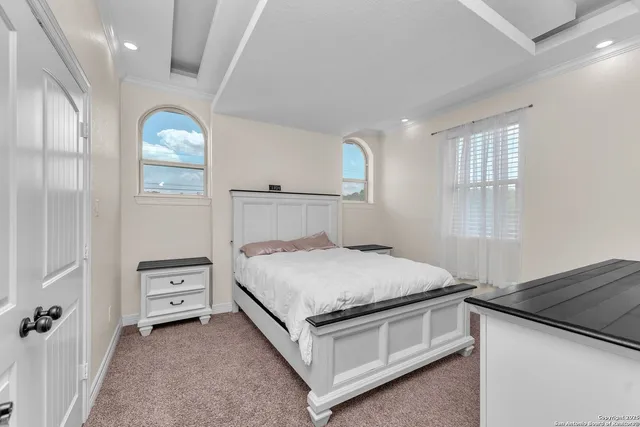 a bedroom with a bed chandelier and a window