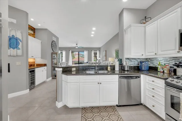 a kitchen with granite countertop white cabinets and stainless steel appliances