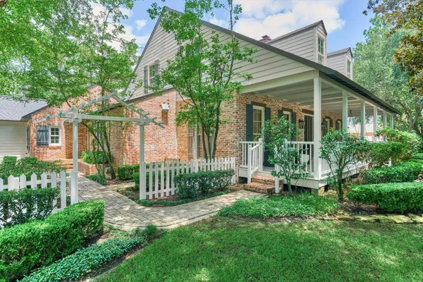 a front view of a house with a garden and plants