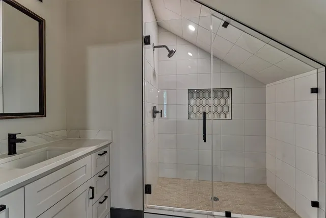 a bathroom with a shower sink and mirror