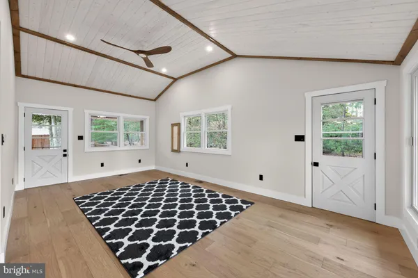 a view of a bedroom with wooden floor and windows