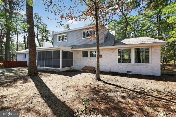 a backyard of a house with wooden fence and a tree