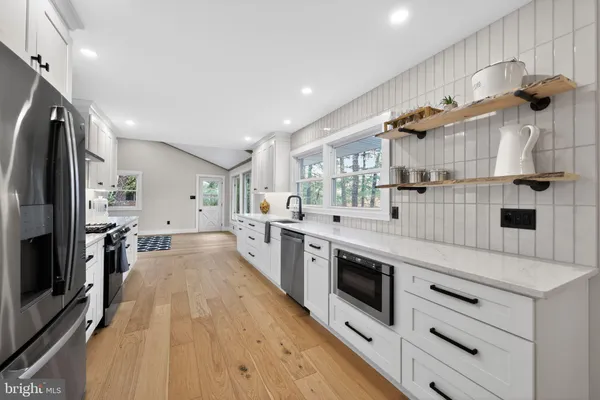 a kitchen with stainless steel appliances kitchen island granite countertop a stove and a sink