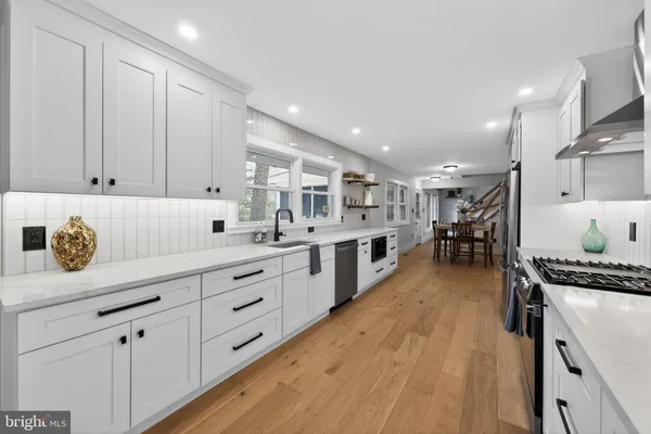 a kitchen with stainless steel appliances granite countertop a lot of counter space and wooden floors