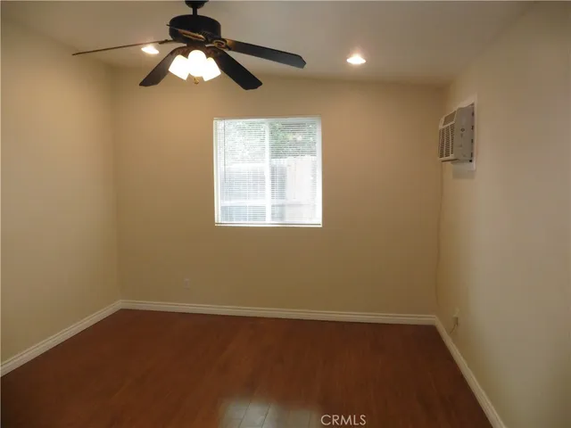 an empty room with a window and a fan