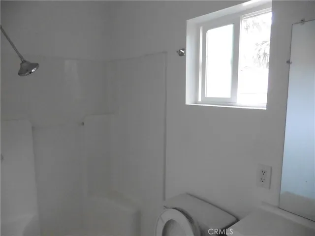 a bathroom with a window a toilet and a window