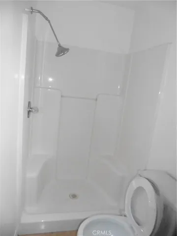 a bathroom with a toilet and a shower